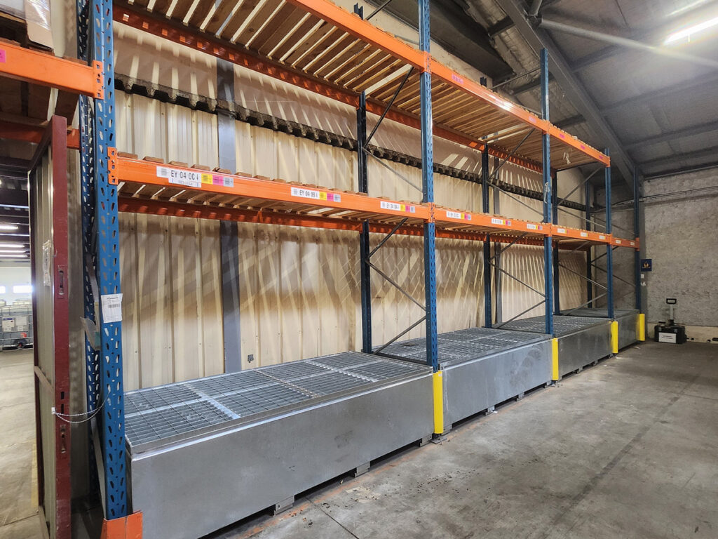 Installation de bacs de rétention de 2 000 litres sous racks de stockage dans un entrepôt logistique à Meyzieu (69)